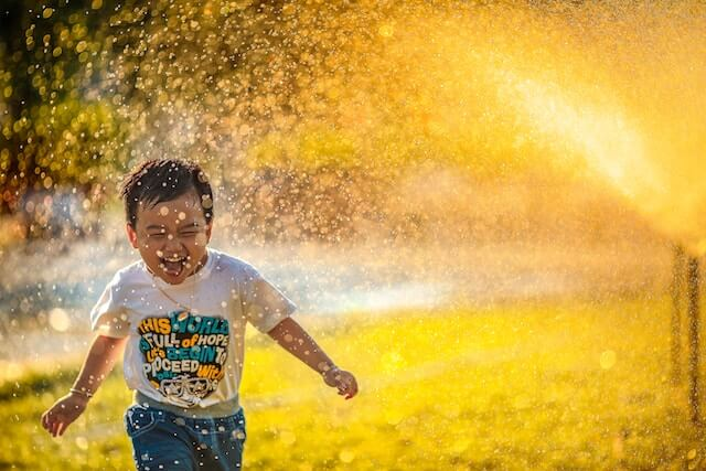 Child with autism playing with a water spray.