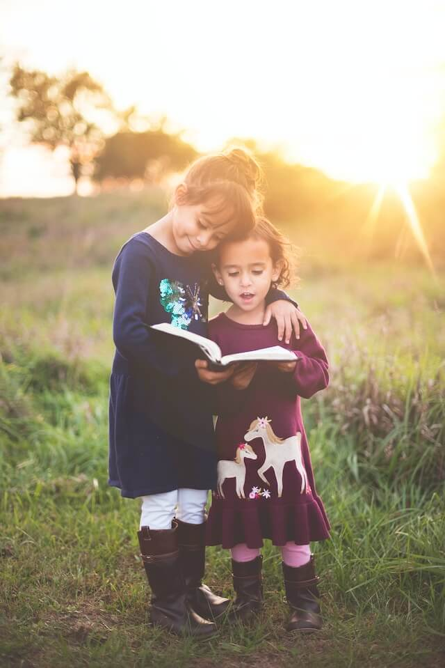 2 girls reading a book | Challenges girls with autism spectrum disorder may face