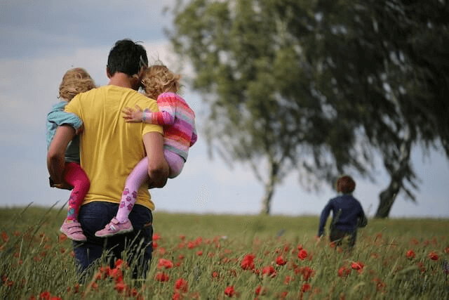 A father carrying his children | Vital Self-Care