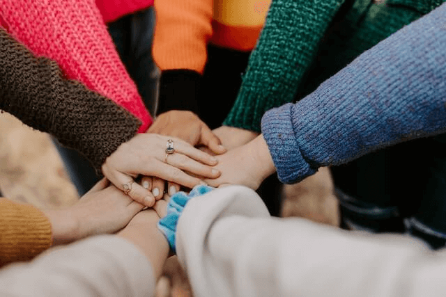 People joining their hands together | Building a Support Network