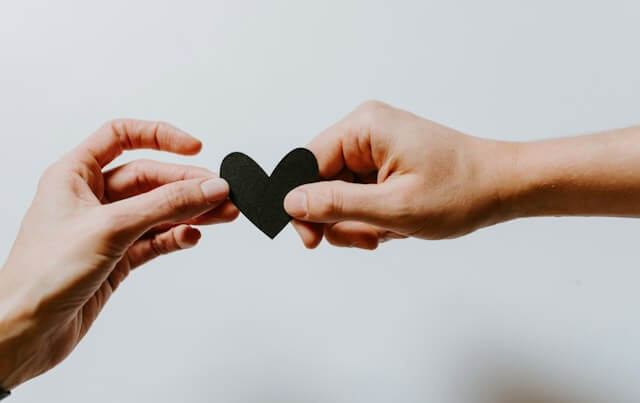 Image of two people holding a heart-shaped paper.
