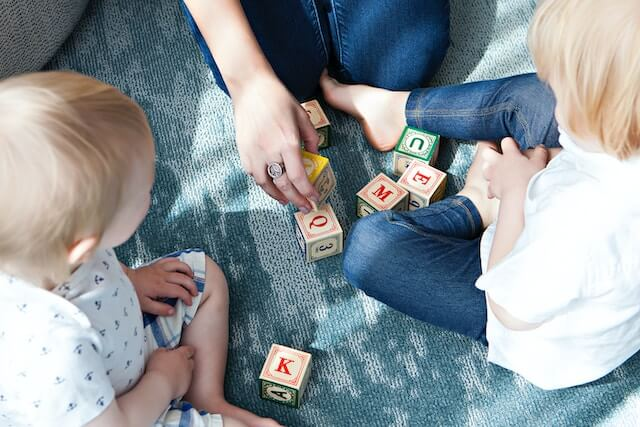 Two children with autism learning with letter blocks.