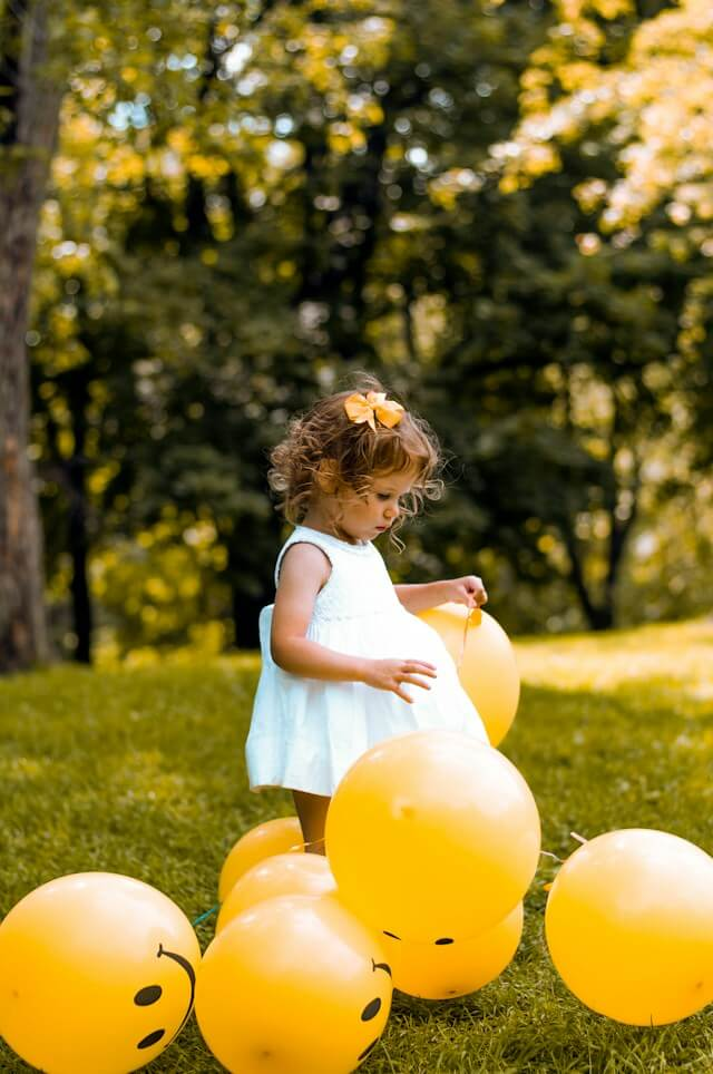 Child with autism playing with balloons adorned with visual cards