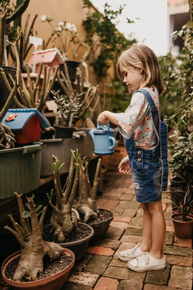Girl watering a plant | The Importance of Fostering Autonomy in Children with Autism